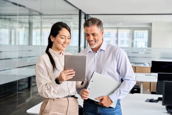 A business man and a woman using digital tablet analysing business data.